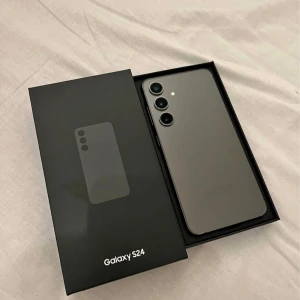 Samsung Galaxy S24 - Säljer en Samsung Galaxy S24 i elegant svart färg. Telefonen har en modern design med tre kameror på baksidan och en stor skärm. Perfekt för dig som vill ha en kraftfull och stilren smartphone. Levereras i originalförpackning.