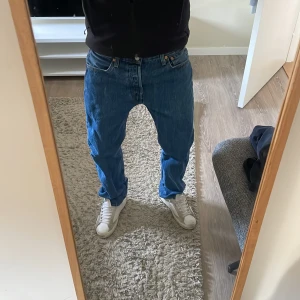 Blå Levis 501 jeans - Säljer ett par schyssta blå Levis 501 jeans. De har normal passform och är i storlek W33 L32. Perfekta för en avslappnad stil. Modellen på bilden är 183cm. Pris kan diskuteras