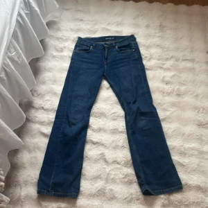 Blå Mira jeans bootcut W28 L32 - Snygga blå jeans från Mira i klassisk bootcut-modell. Jeansen har fem fickor, normal passform och är tillverkade i slitstarkt denimtyg. Perfekta för dig som gillar en tidlös look med lite utsvängda ben.