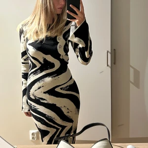 Svart och beige långklänning med mönster - Klänning från nakd