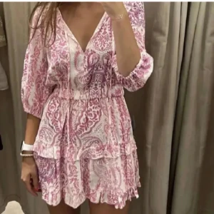 Zara sommarklänning - Superfin sommarklänning från Zara med v-ringning, trekvartsärmar och blommigt mönster i rosa och lila. Endast använd en gång🩷