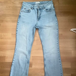 Ljusblå bootcut jeans - Ljusblå jeans med bootcut passform från Gina Tricot. Klassisk femficksmodell med stora bakfickor och dragkedja. Jeansen har hög midja och är tillverkade i robust denim för en snygg och avslappnad look.