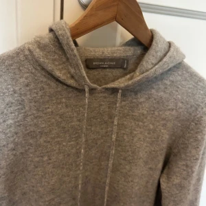 Grå Kashmir hoodie - Sjukt snygg och skön Kashmir hoodie från märket Brown Avenue. Nypris 2999kr. Storlek M, passar även S. 100% Kashmir. Hoodien är endast använd ett fåtal gånger och är i jättebra skick utan några defekter. Säljer den då den är för liten för mig. Ifall ni undrar något är det bara att höra av sig.
