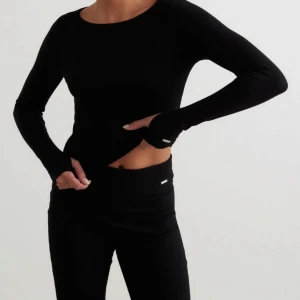 Svart set från Aim'n - Svart set från Aim'n i mjuk i stretchig bomullsmix. Tight passform med rund halsringning och diskret Aim'n-logga vid ärmslutet. Perfekt basplagg för lager-på-lager eller till träning. Snygg och enkel att matcha med allt.