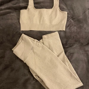 Beige ribbad linnetopp Aim'n - Säljer en beige ribbad linnetopp från Aim'n. Toppen har breda axelband, fyrkantig ringning och är croppad. Perfekt för träning eller chill dagar. Materialet är stretchigt och mjukt för maximal komfort.