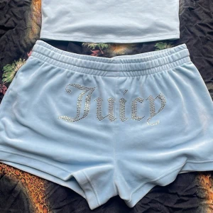 Ljusblå Juicy Couture shorts - Supermjuka ljusblå shorts från Juicy Couture med glittrande strassbokstäver över baken. Klassisk loose fit med resår i midjan och korta ben. Perfekta för chill dagar eller när du vill ha en ikonisk Y2K-look. För båda 
