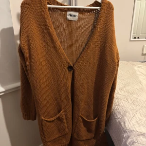 Brun stickad kofta från Acne i S - Säljer en oversized brun stickad kofta från Acne med djup v-ringning. Knappt använd 