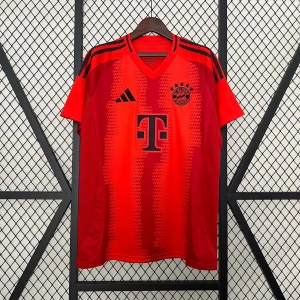 Röd Bayern München fotbollströja Adidas - Snygg röd Bayern München fotbollströja från Adidas med svarta detaljer och klubbmärke på bröstet. Tröjan har korta ärmar, V-ringning och klassiska Adidas-ränder på axlarna. Tillverkad i lätt och ventilerande material, perfekt för match eller träning.