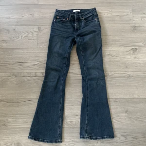 Bootcut jeans från Gina Tricot, mörkblå - Mörkblå bootcut jeans från Perfect Jeans med klassisk femficksdesign och snygga kopparfärgade nitar. Jeansen är low bootcut och är tillverkade i mjukt denimtyg som sitter skönt hela dagen.