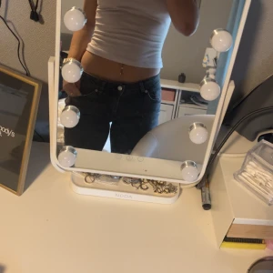 Svarta jeans med fickor - Säljer ett par svarta jeans med snygg tvätt och stora bakfickor med lock och knapp. Jeansen har låg midja och klassisk femficksdesign. De är tillverkade i ett mjukt bomullsmaterial med lite stretch för extra komfort. De är lite nersydda men det är inget fel med dom ( dem har INTE spruckit eller vart dåligt sydd). Köpta på Ullared 