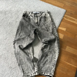 Acid wash jeans från Polar Skate Co. - Säljer ett par grymma acid wash jeans från Polar Skate Co. i svart och grått. Modellen är loose fit med breda ben och klassisk femficksdesign. Snygg broderad logga på fickan och coolt 93!DENIM-märke i midjan. Perfekta för en avslappnad streetstil.