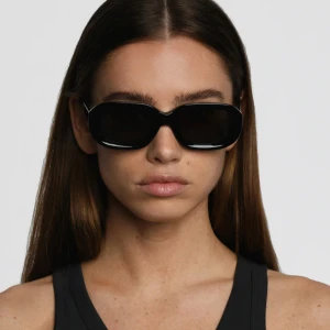 Svarta solglasögon Corlin Eyewear - Snygga svarta solglasögon från Corlin Eyewear med rektangulära bågar och mörka glas. Stilren och trendig modell som passar perfekt till en modern look. Kommer med originalfodral och box.
