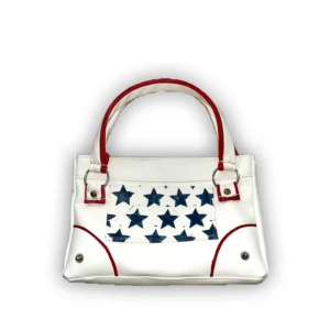 Vit handväska med blå stjärnor - Cool vit handväska med blå stjärnor på framsidan och röda detaljer på handtag och kanter. Bredd:25cm höjd: 16cm