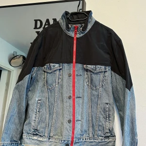 Levi's jeansjacka  - Snygg jeansjacka från Levi's Premium med svarta partier upptill och på ärmarnar. Perfekt för dig som vill sticka ut med en unik och modern look. Helt ny, använt bara en gång