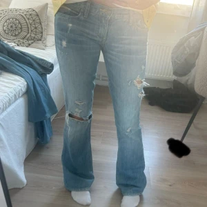 Ljusblå bootcut jeans med slitningar - säljer dessa sjuuuukt snygga lågmidjade vintage jeans från märket abercrombie 😍😍 midja 37-38cm, går att göra mindre eller större i midjan eftersom de finns två knappar. innerbenslängd:81cm 💞 inga defekter