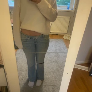 Lågmidjade bootcut jeans  - Säljer ett par ljusblå jeans med bootcut passform. Jag har sytt de lågmidjat och gjort hålet själv skriv vid intresse ! Midjemåttet är ungifär 36-38