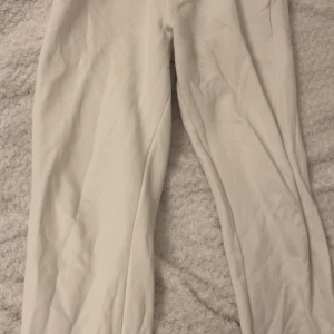 Vita mjukisbyxor från Paul Mark S - Vita mjukisbyxor från Paul Mark i storlek S. Byxorna har resår i midjan och är gjorda i mjukt bomullstyg. Perfekta för chill dagar eller när du vill vara bekväm. Klassisk passform med raka ben och sidfickor.