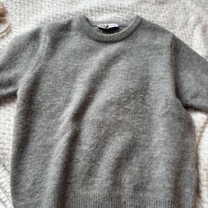 Grå stickad tröja från Zara - Säljer en jättefin grå stickad kortärmad tröja, perfekt för hösten!🍁Den är lite nopprig på vissa ställen annars inga tecken på slitage💘Skriv för frågor och funderingar!