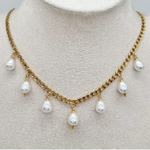 Guldhalsband med pärldroppar - Snyggt halsband i guldtonad kedja med hängande vita pärldroppar. Kedjan har chunky länkar och varje pärla avslutas med en liten gulddetalj. Perfekt för att ge din outfit en elegant och trendig touch.Längd-40cm,kedjetjocklek-4cm