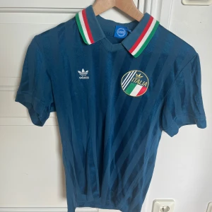 Italien retro fotbollströja Adidas - En adidas tröja med en remake på en gammal Italien landslagströja. Pris går att diskutera vid snabb affär, hämtas i Barkarby station eller fraktas där du står för frakten.