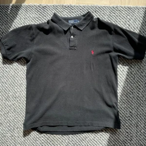 Svart Ralph Lauren pike med röd logga - Klassisk svart Ralph Lauren pike med röd logga