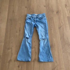 Ljusblå low boot jeans - Säljer ett par ljusblå jeans med lowboot modell. Jeansen har klassisk femficksdesign, normal midja och är tillverkade i mjukt denimtyg. Perfekta för dig som gillar en avslappnad och trendig look.