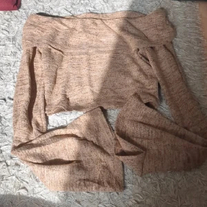 Beige offshoulder croppad tröja - Säljer en beige offshoulder tröja med croppad passform och långa ärmar. Tröjan har en mjuk stickad känsla och är perfekt för dig som gillar trendiga och bekväma plagg. Passar dig som vill ha en chill och snygg look.