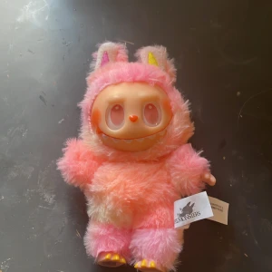 Big Into Energy - En färgglad och fluffig samlarfigur från The Monsters-serien, klädd i rosa och gul päls med stora ögon och gulliga öron. Perfekt för dig som gillar unika och lekfulla prylar att ha i bokhyllan eller på skrivbordet. Inte äkta!! 