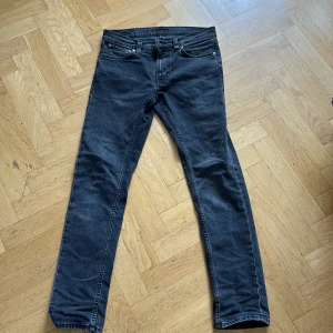 Nudie Jeans Lean Dean Black Eyes 28/32 - Säljer ett par svarta Lean Dean Black Eyes jeans från Nudie Jeans i storlek 28/32. Jeansen har en slim passform. Snygg tvättad svart färg. skriv för frågor eller funderingar.