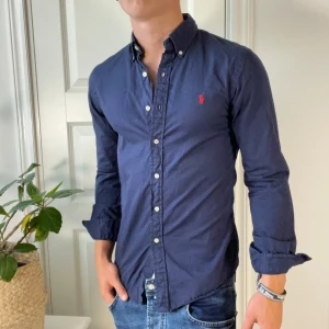 Mörkblå Ralph Lauren skjorta  - Inga defekter, modellen är 180,75 kg och bär S vilket är lite litet på honom som ni ser 🙌