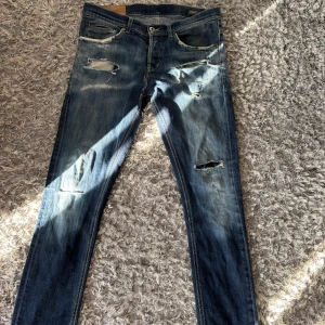 Blå slitna skinny jeans med hål - Säljer ett par blå skinny jeans med slitningar. Dom har en skada i skrevet med den är deskret lagad