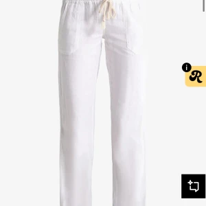 Vita linnebyxor med snörning - Snygga vita linnebyxor med avslappnad passform och dragsko i midjan. Byxorna har raka ben, resår i midjan och praktiska fickor framtill. Perfekta för en chill och luftig stil under varma dagar.