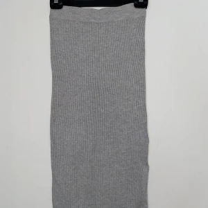 Grå ribbad långkjol Gina Tricot - Supersnygg grå långkjol från Gina Tricot i ribbad stickad kvalitet. Kjolen har en rak och slim passform som sitter skönt och följer kroppen. 