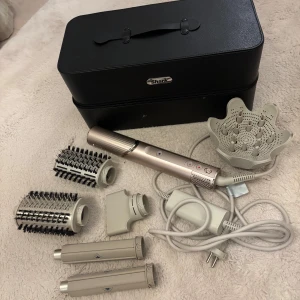 Shark FlexStyle stylingverktyg med väska - Shark FlexStyle multifunktionellt stylingverktyg med flera utbytbara tillbehör, inklusive rundborstar, locktillbehör och diffuser. Kommer i en snygg svart väska med handtag. Färgen på verktyget är metallic champagne och beige. Ni kan läsa mer om den online. Nypris 3499kr, endast provad 2 gånger!