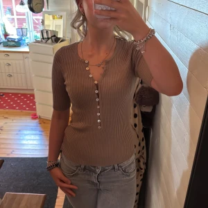 Brun tröja med knappar - En brun tröja med knappar och litte längre på armarna från lindex. Endast använd en gång på påskafton.