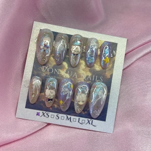 Xavier Dream (XS);Medium Almond - Superfina handgjorda press-on naglar med animeinspirerade (Xavier) motiv, glittereffekt och 3D-dekorationer som stjärnor och blommor. Lila och nude bas med skimrande yta och detaljer i vitt och guld. Långa, mandelformade tippar. Perfekt för dig som vill ha unika och kreativa naglar. I storlek XS: 14 mm, 11 mm, 11,5 mm, 10 mm, 8 mm 