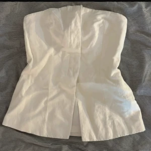 Vit linnetopp från H&M, axelbandslös - Säljer denna tubtopp då den inte passar mig, inte använd så den är i bra skick!💓
