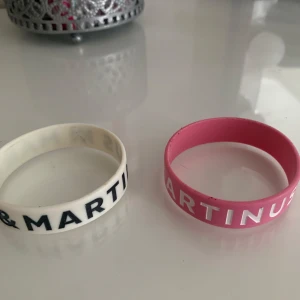 Marcus & Martinus armband i silikon - Två coola armband i silikon med Marcus & Martinus-tryck. Ett är vitt med svart text och det andra är rosa med vit text. Perfekt för dig som är fan av Marcus & Martinus och vill visa det på ett snyggt sätt.