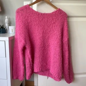 Oversized stickad rosa tröja - Supermysig oversized stickad tröja i stark rosa färg. Tröjan har grovstickat material och långa ärmar, perfekt för att hålla sig varm och ändå se trendig ut. Passar dig som gillar en chill och avslappnad stil.