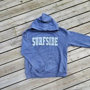 Hoodie - Dammblå hoodie med ljusblått tryck framtill. Helt ny och oanvänd! Storlek 160 men passar även XS (34). Mjukt material, superfin färg och perfekt passform!