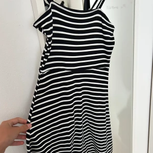 Randig kortklänning från H&M Divided - Säljer en svartvit randig kortklänning från H&M Divided i storlek 32. Klänningen har smala axelband och är tillverkad i mjuk bomull. Den har en figurnära passform upptill och lätt utsvängd kjol. Väldigt fin klänning men är lite kort för min smak.pris går att diskutera🤍🖤🩶