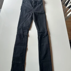 Svarta skinny jeans från NLY Jeans - Snygga svarta skinny jeans från NLY Jeans med klassisk femficksmodell och smal passform hela vägen ner. Jeansen är i stretchigt denimtyg som sitter tajt och bekvämt. Perfekta till sneakers eller boots för en clean look. Storlek S