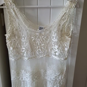 Vit beige Blus från Vero Moda - Superfin vit spetsblus från Vero Moda i storlek M. Den har ärmlös design och är täckt av detaljerad spets med blommigt mönster. Den har rundad hals och transparent mesh med broderade blommor, perfekt för sommarens alla tillfällen.