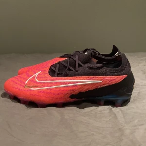 Nike Phantom GX rosa/svart storlek 42 1/2 - Nike Phantom GX fotbollsskor med en snygg mix av rosa och svart. Kan användas både gräs och konstgräs.