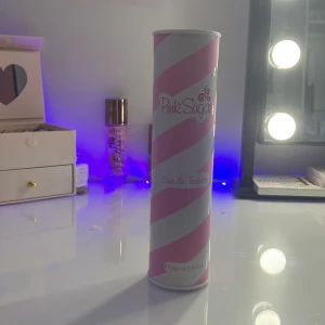 Pink Sugar Eau de Toilette 100ml - Säljer en söt och lekfull parfym från Pink Sugar, Eau de Toilette i 100 ml. Flaskan kommer i en cylinderformad förpackning med rosa och vita diagonala ränder, inspirerad av sockervadd. Tillverkad i Italien, perfekt för dig som gillar söta dofter. Den är väldigt söt och behövs inte många sprut av parfymen för att få en doft som håller hela Dan!💕💕