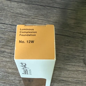 BeautyAct Luminous Foundation 12W - Luminous Complexion Foundation i nyansen 12W från BeautyAct by Kicks. Ger en naturligt glowig finish med medium täckning. Kommer i en stilren vit och guldig förpackning. Perfekt för dig som vill ha en fräsch och jämn hudton med lång hållbarhet.