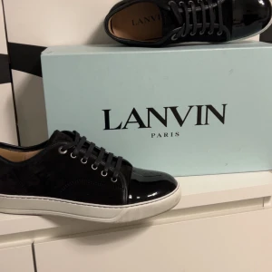 Svarta sneakers från Lanvin - Snygga svarta sneakers från Lanvin med vit sula och svarta skosnören storleken e 39 men passar även 40-41 priset e inte hugget i sten. Om affären går snabbt. Har använt dom 2-3 gånger köpte dom helt nya från nk så påse box kvitto nk påse fårs med 