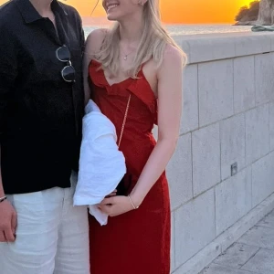 Röd sommarklänning - Supersnygg röd klänning från Zara med volang vid urringningen. Klänningen har smala axelband, öppen rygg och figurnära passform. Perfekt för sommarkvällar när du vill sticka ut lite extra.