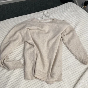 Beige stickad tröja från Vero Moda - Mysig beige stickad tröja från Vero Moda i storlek S. Tröjan har rund halsringning, ribbade muddar och är långärmad. Perfekt för lager-på-lager och chill höst- eller vinterstil. Säljer den för att den sällan kommer till användning. Tvättar den innan leverans. 