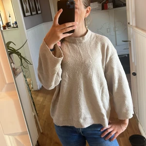 Beige stickad tröja med lös passform - Mysig beige stickad tröja med högre ribbad halsringning och avslappnad, loose passform. Tröjan har långa ärmar och ribbade muddar vid ärmslut och nederkant. Perfekt för lager-på-lager under kyliga dagar även att bara ha något en kyligare sommarkväll💕💕